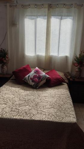 a bed with two pillows and a window at Apartamento in Belém