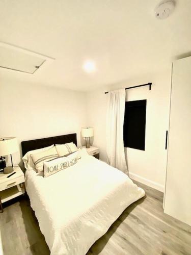a white bedroom with a bed and a window at Newly built Guest House near beaches in Costa Mesa