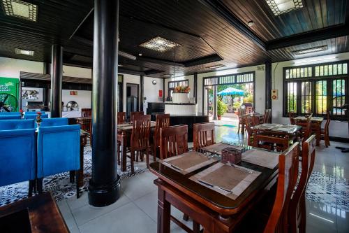 a dining room with wooden tables and chairs at Hoian Nostalgia Hotel in Hoi An