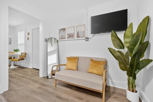 a living room with a couch and a tv on a wall at Affordable Private Studio in Pensacola
