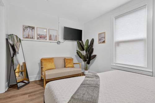 a bedroom with a bed and a chair and a tv at Affordable Private Studio in Pensacola