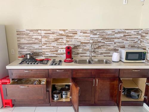a kitchen with a sink and a microwave at Guest Favorite - Central - Gated - 2 Bedrooms in Willemstad