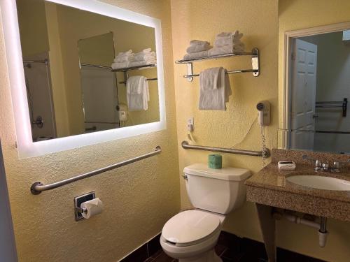 a bathroom with a toilet and a sink and a mirror at Studio 6 Suites Pasadena, TX in Pasadena
