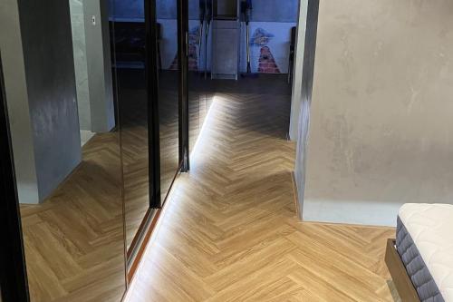 a room with a wooden floor and a glass door at Spaceous Appartment on Sukhumvit in Bangkok