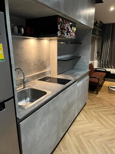 a kitchen with a sink and a stainless steel counter at Spaceous Appartment on Sukhumvit in Bangkok