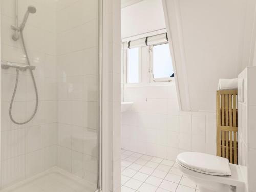 a white bathroom with a shower and a toilet at Comfortable Waterfront Park Retreat in Midlaren