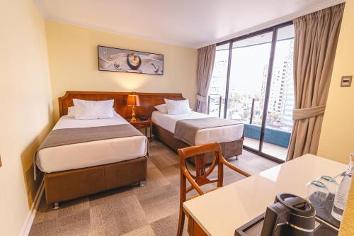 a hotel room with two beds and a balcony at Ocean Boulevard in Iquique