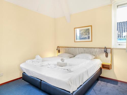 a bedroom with a large bed with white sheets at Waterfront Villa Near Groningen in Midlaren