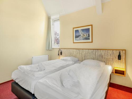 a bedroom with a large bed with white sheets at Waterfront Villa Near Groningen in Midlaren