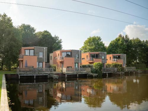 a row of modular homes next to a river at Waterfront Retreat in Drenthe in Midlaren