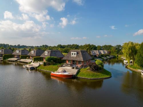 an aerial view of a river with houses and a boat at Holiday Home in De Bloemert in Midlaren