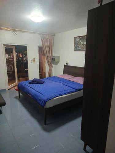 a bedroom with a bed with a blue comforter at Udon Thai House Resort & Hotel in Udon Thani