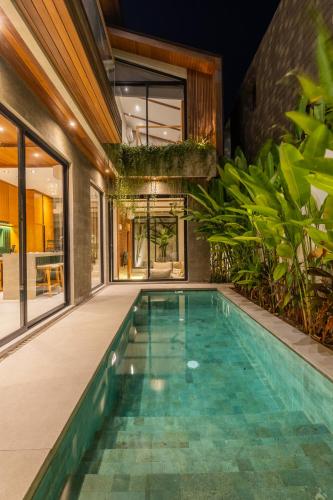 an indoor swimming pool in a house at Nanna Villa Unit 2 by Betterplace in Tumbak Bayuh