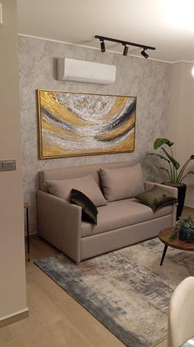 ein Wohnzimmer mit einer Couch und einem Gemälde an der Wand in der Unterkunft APARTAMENTO DE LUJO en HERA TOWER in La Playa Bejarano