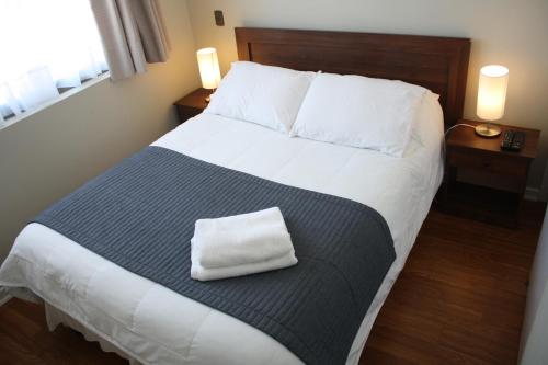 Un dormitorio con una cama grande con una toalla. en Hostal Buró, en Concepción
