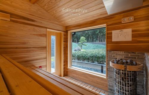 a room with a fireplace and a window at Craft Inn WARAKU in Shizuoka