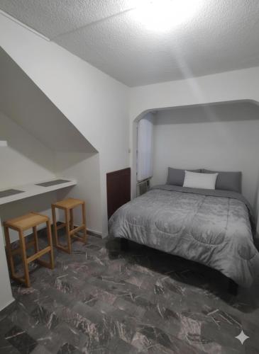 a bedroom with a bed and two tables in it at Santafe Suites in Hermosillo