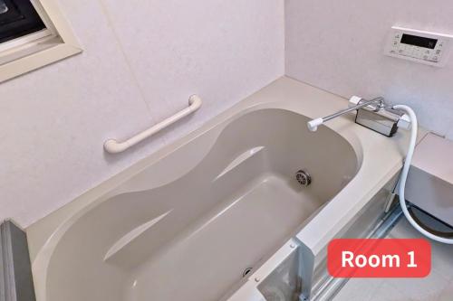 a bath tub in a bathroom with a sign that reads room at Vacation House 1 in Funabashi