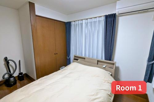 a bedroom with a bed with a room sign at Vacation House 1 in Funabashi
