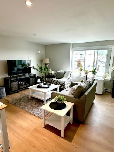 a living room with a couch and a tv at Modern One-Bedroom Retreat in Bear Mountain in Langford