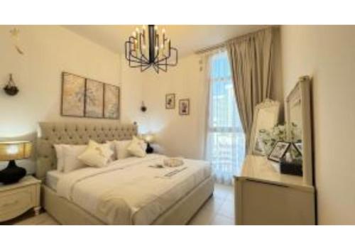 a bedroom with a large bed and a chandelier at 1BR Urban Oasis - Chic Poolside Retreat in Abu Dhabi