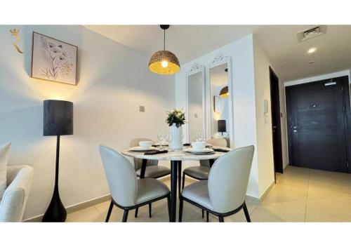 a dining room with a table and chairs at 1BR Urban Oasis - Chic Poolside Retreat in Abu Dhabi