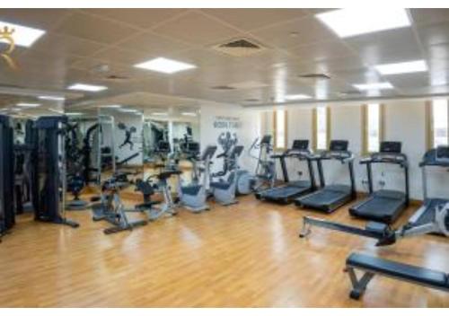 a gym with rows of treadmills and elliptical machines at 1BR Urban Oasis - Chic Poolside Retreat in Abu Dhabi