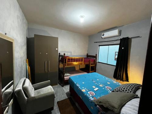 a bedroom with a bed and a chair in it at Loft individual Mobiliado com Ar-condicionado B in Dourados