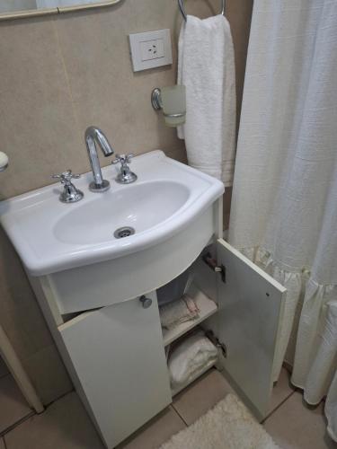 a bathroom with a sink and a shower curtain at Excellent Monoambiente in Santos Lugares
