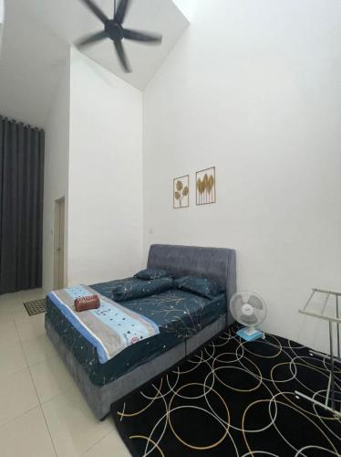 a bed in a room with a ceiling fan at The Indah Homestay Gerik in Gerik