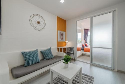 Ban KathuにあるA Stylish Condo in Local Area Kathu, Phuketのソファとテーブルのあるリビングルーム