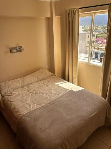 a bed in a room with a window at Amplio depto a estrenar a metros de plaza principal in San Fernando del Valle de Catamarca