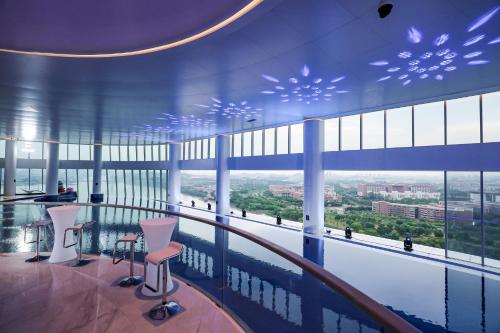 a room with a large window with a pool and chairs at Vignette Collection The Xanadu Guangzhou, an IHG Hotel in Guangzhou