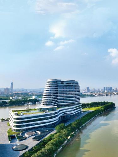 a large building next to a river with a city at Vignette Collection The Xanadu Guangzhou, an IHG Hotel in Guangzhou