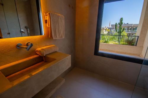 a bathroom with a sink and a mirror and a window at Villa Piscine Privée, Petit déjeuné et ménage inclus in Marrakech