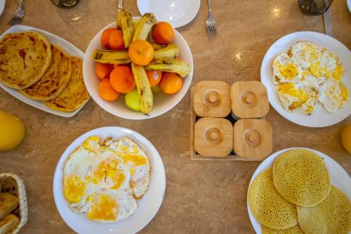 a table topped with plates of eggs and fruit at Villa Piscine Privée, Petit déjeuné et ménage inclus in Marrakech