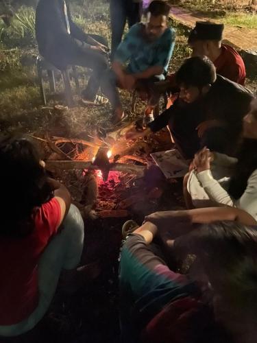 a group of people sitting around a fire at Time Travellers Hostel in Auroville