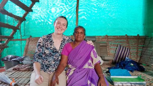 a man and a woman sitting on a bed at Time Travellers Hostel in Auroville