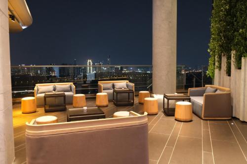 a balcony with chairs and tables on a building at Vignette Collection The Xanadu Guangzhou, an IHG Hotel in Guangzhou