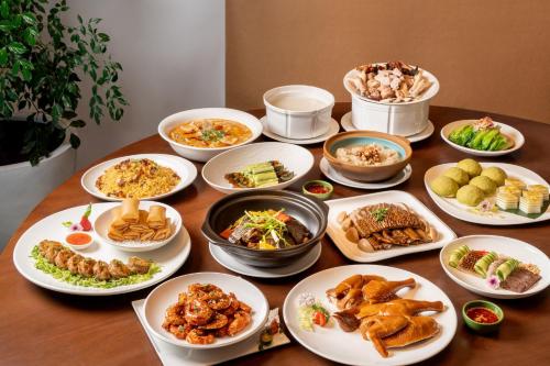 a table with many plates of food on it at Vignette Collection The Xanadu Guangzhou, an IHG Hotel in Guangzhou