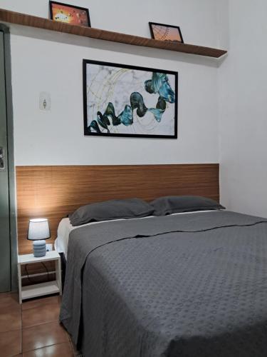 ドゥケ・デ・カシアスにあるQuarto econômico 25 de agostoのベッドと壁に絵が飾られた寝室