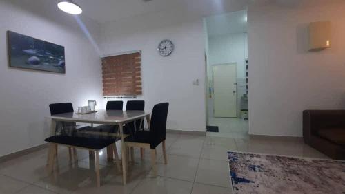 a dining room with a table and chairs and a clock at Cozy Homey in Pancur