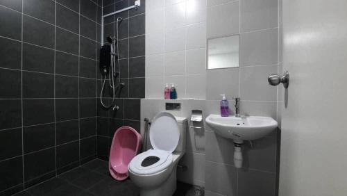 a bathroom with a pink toilet and a sink at Cozy Homey in Pancur
