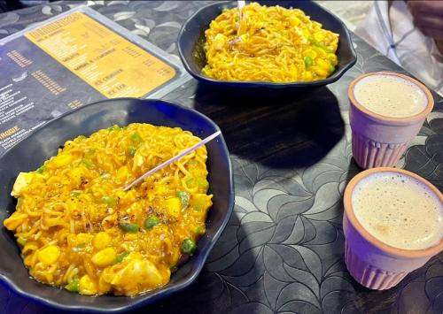 two dishes of food and two cups of drinks on a table at HOTEL SHIVAYY MAJESTIC - BHU Sundarpur Road 3km from KASHI VISHWANATH TEMPLE in Varanasi