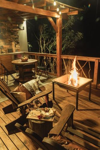 a patio with a fire pit on a wooden deck at Santuá - Cabana Bellagio in Rio dos Cedros