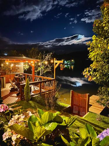 a deck with a view of a lake at night at Santuá - Cabana Bellagio in Rio dos Cedros