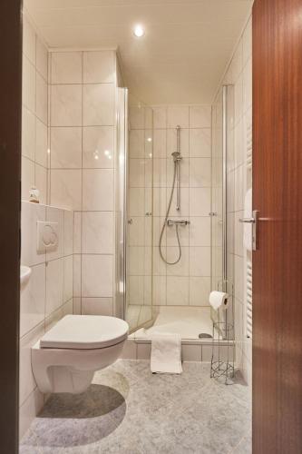 a bathroom with a shower and a toilet and a sink at Rotesand - 117 in Cuxhaven