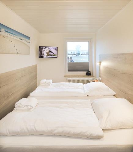 a group of four beds in a room at Rotesand - 117 in Cuxhaven