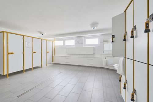 a large bathroom with white walls and yellow doors at Knechtsand - 403 in Cuxhaven