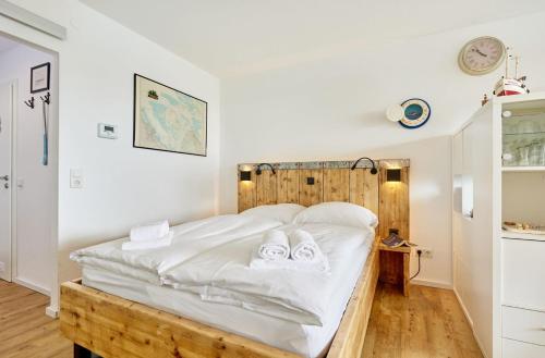 a bedroom with a bed with white sheets and towels at Nautic - 306 in Cuxhaven